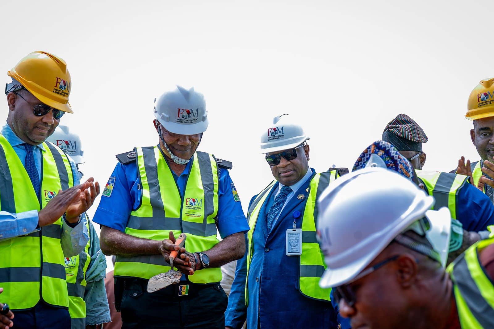 Officials in safety helmets at the ground-breaking